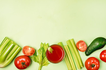 Background or Flat Lay with Glass of Tasty and Healthy Tomatoes and Celery Juice Raw Tomatoes Celery and Avocado on Green Background Top View Flat Lay Copy Space