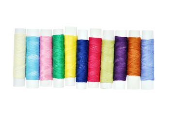 Many colorful thread bobbins isolated on white for hand made concept design