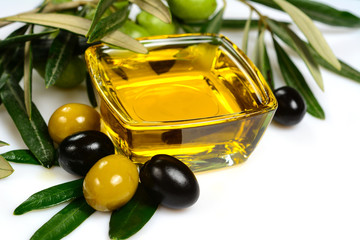 Olive oil. Greek olive oil in square glass transparent bowl with branches, leaves and with green...