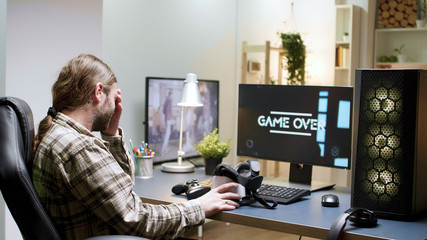Man sitting on gaming chair taking off his vr headset © DC Studio