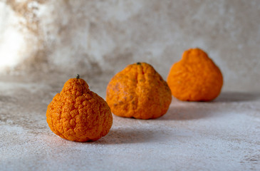 Ugly organic mandarins with rough thick skin. Trendy ugly fruit concept. Copy space, horizontal orientation