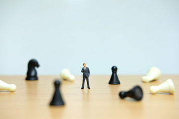 Business strategy conceptual photo - Miniature of businessman standing in the middle of collapsing...