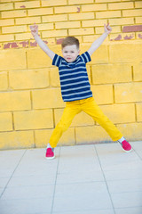 Little boy posing against the wall