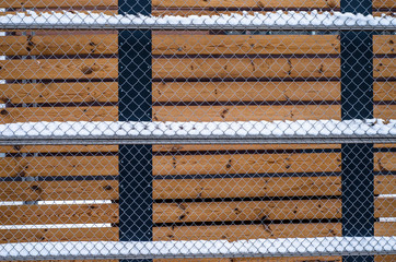 Rabitz. Winter background with diagonal metal mesh and wooden boards. Fencing for the safety of the...