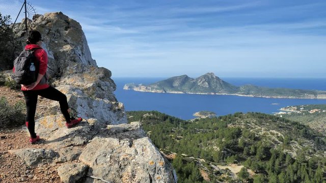 Woman hiker watch from Pintal Vermell peak treck the Sant Elm village and Sa Dragonera island. Mallorca or Majorca is the largest island in the Balearic Islands