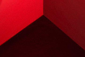 Red paper cube with shadows. Origami closeup. Graphic neutral background.