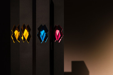 Black paper abstract object with shadows and color inserts. Origami closeup. Graphic neutral...