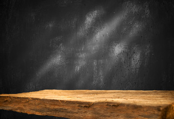 Empty wooden table on a background of dark blurred wall, empty space for product above