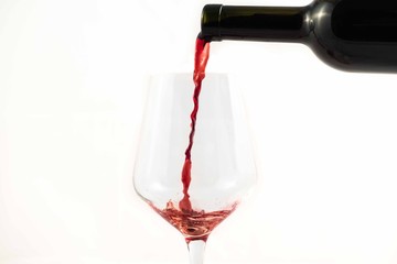 red wine splash in a glass on a white background