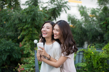 Two young Asian woman hugging in the balcony