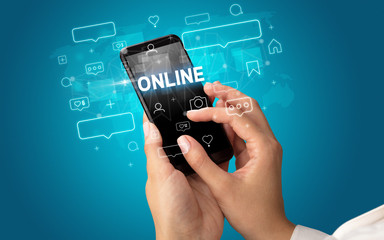 Female hand typing on smartphone with ONLINE inscription, social media concept
