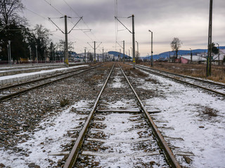 Obraz premium Rail road tracks at wintertime near a small town in Romania.