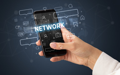 Female hand typing on smartphone with NETWORK inscription, social media concept