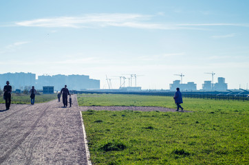 The construction of residential buildings in the new urban area. Technology of artificial embankment of the islands. Green lawn on the background of the city. Development of road infrastructure. 