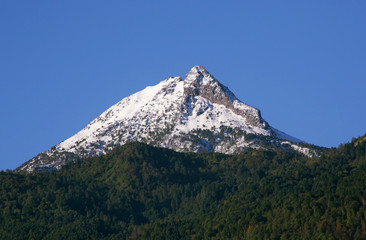 Amazing mountain peak covered by snow on a clear blue sky - Powered by Adobe