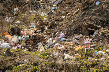 Fototapeta premium A pile of trash abandoned on the grass, littering and polluting the environment