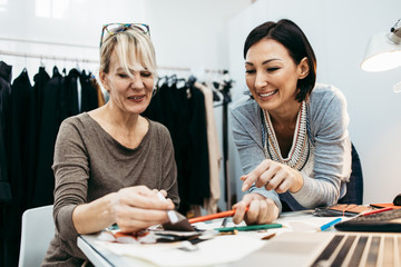 Two professional designers working in fashion studio. Creative people concept.