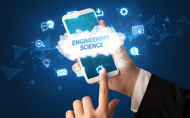 Female hand holding smartphone with ENGINEERING SCIENCE inscription, cloud technology concept