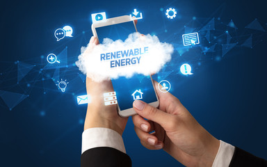 Female hand holding smartphone with RENEWABLE ENERGY inscription, cloud technology concept