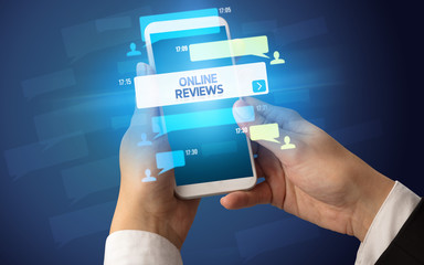 Female hand typing on smartphone with ONLINE REVIEWS inscription, social networking concept