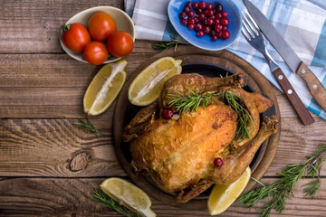 Roast chicken with spices and lemon on cutting board in wooden table