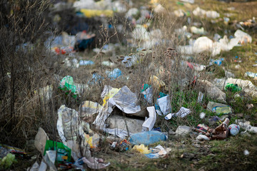 A pile of trash abandoned on the grass, littering and polluting the environment