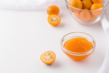 kumquat jam on a white plate next to fresh fruit. copy space