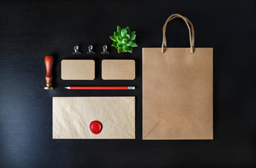 Blank kraft stationery set on black wooden background. Corporate identity template. Responsive...