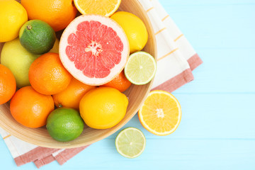 Different citrus and juicy slices on a colored background top view. Place to insert text.