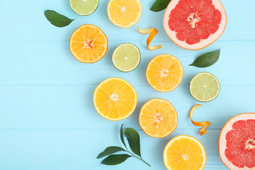 Different citrus and juicy slices on a colored background top view. Place to insert text.