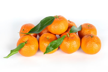 Appetizing tangerines with green leaves on a white background with a light shadow. Tangerines are delicious low-calorie citrus rich in vitamins and minerals