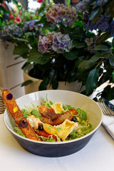 Starter of fried duck liver, camembert and lettuce served outdoors