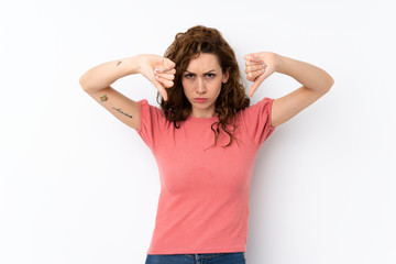 Young pretty woman over isolated background showing thumb down