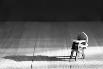 Infertility concept, lack of children in the family Empty chair for feeding children on a wooden...