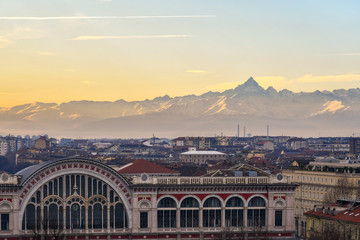 Elevated view of the city centre of Turin with the mountain range of the Alps and Monviso peak in the background at sunset, Turin, Piedmont, Italy