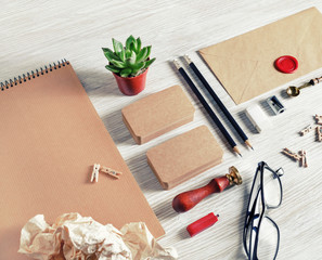 Blank kraft paper stationery set on light wood table background. Template for branding identity....