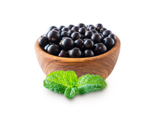 Black berries isolated. Blackcurrants in a wooden bowl isolated on white background. Blackcurrants with mint on white. Blackcurrants isolated on white background. Top view.