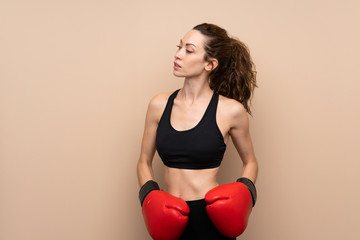 Young sport woman over isolated background with boxing gloves