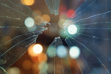 Abstract city lights background behind the dirty broken glass