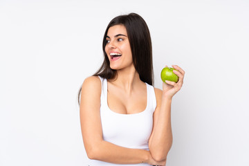 Young woman over isolated white background with an apple and happy