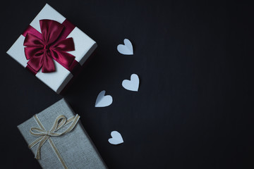 Gift boxes and hearts on a black background