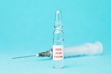 Coronavirus 2019-nCoV vaccine ampoule on blue background