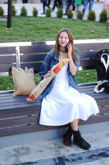 Beautiful girl eat baguette on the street