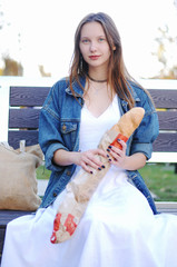 Beautiful girl eat baguette on the street