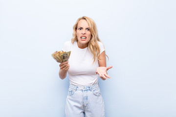 young blonde woman looking angry, annoyed and frustrated screaming wtf or what‚Äôs wrong with...