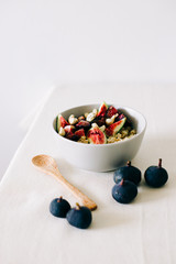 healthy Breakfast oatmeal with figs and cashews on a white table. vegan food