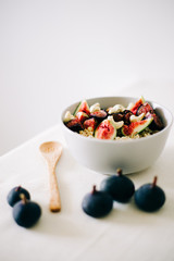 healthy Breakfast oatmeal with figs and cashews on a white table. vegan food