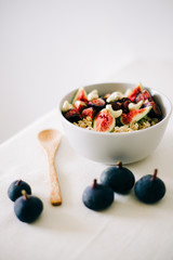 healthy Breakfast oatmeal with figs and cashews on a white table. vegan food