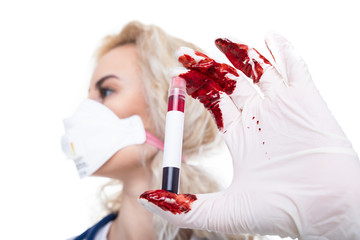 The girl doctor holds a test tube with blood that spilled on the glove. The epidemic of coronavirus