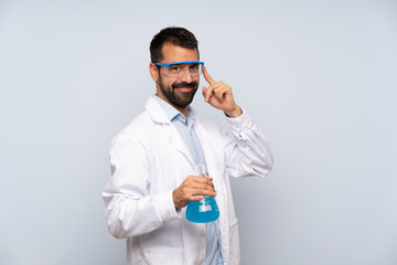 Young scientific holding laboratory flask over isolated background with glasses and smiling